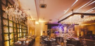 Sala z własnym cateringiem czy zewnętrzną firmą – które rozwiązanie daje większą swobodę? Elegancka sala bankietowa z żyrandolami i kwiatami na przyjęcie okolicznościowe