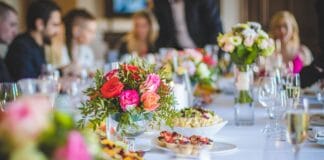 Jak skomponować eleganckie menu na stypę w restauracji z zachowaniem tradycji i szacunkiem dla wszystkich gości Elegancko nakryty stół w restauracji z kwiatami na stypę