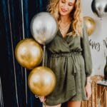 Uśmiechnięta kobieta z balonami na eleganckiej imprezie sylwestrowej