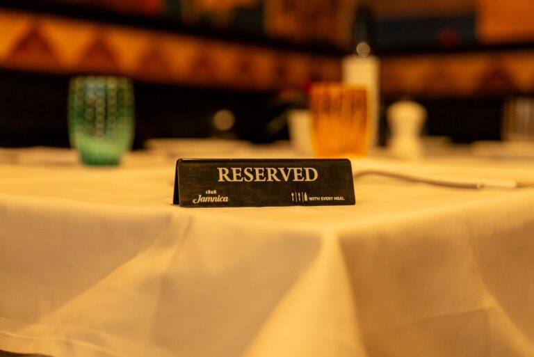 Tabliczka Rezerwacja na białym obrusie w restauracji